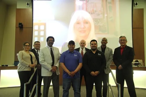 Jairo Aguayo (center-left, in blue shirt) and Roberto Montes Garcia (center-right, wearing black) are honored by the City Council of Commerce City in recognition of saving a shooting victim's life.